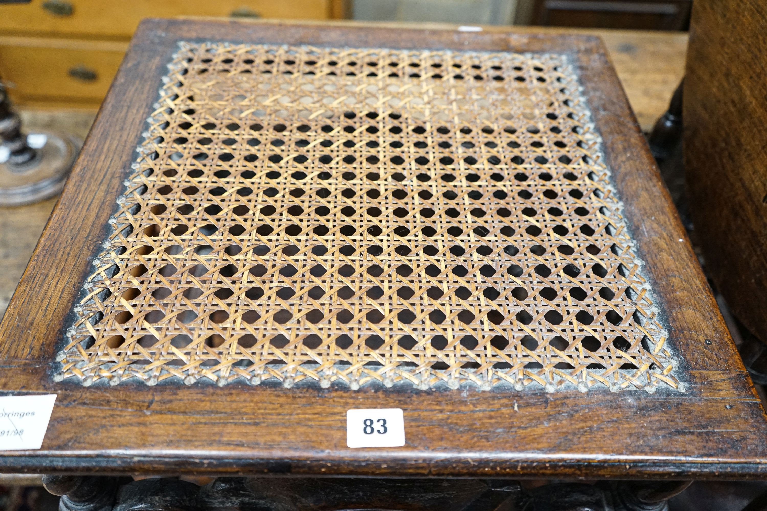 A 17th century style carved oak stool, with caned seat and H stretcher, width 47cm, depth 46cm, height 42cm